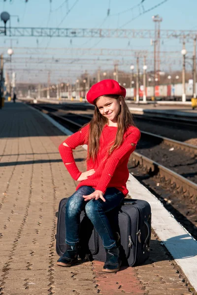 Portrét roztomilé krásné radostné dívka sedí na kufru — Stock fotografie