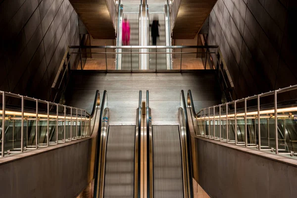 Rote und schwarze Silhouetten von Menschen auf der U-Bahn-Rolltreppe (opp — Stockfoto