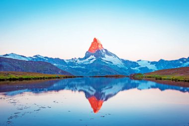 İsviçre 'nin Zermatt kenti yakınlarındaki İsviçre Alpleri ve Stellisee Gölü' nde sabah güneşi altında Matterhorn Dağı 'nın tepesinden aydınlatılan muhteşem manzara. Harika bir yer. (Uyum, meditasyon - kavram)