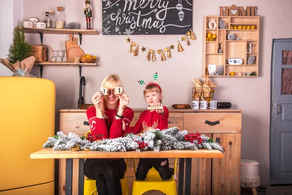 Giovane donna attraente sorridente con sua figlia in cucina — Foto Stock