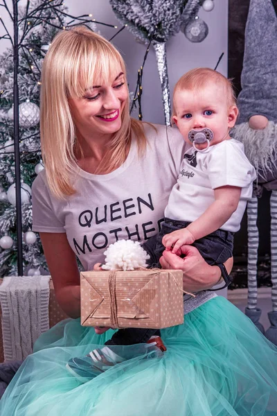 Giovane madre con piccolo figlio vicino decorativi alberi di Natale su — Foto Stock