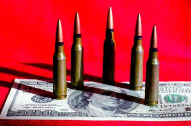 Kırmızı arka planda yüz dolarlık banknotlardaki mermiler abstrac.