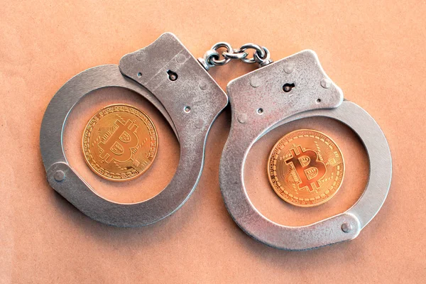 Bitcoins und Handschellen als abstraktes Symbol des Verbrechens, das sich — Stockfoto