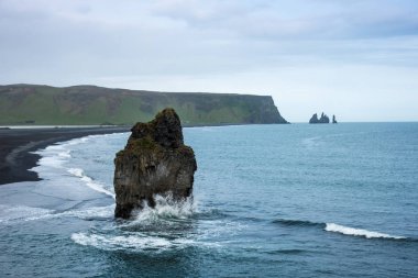 Reynisdrangar Denizi Kayalıkları 'nın yakınındaki, Dyrholaey Burnu ve Vik, İzlanda yakınlarındaki büyük yalnız taşlı büyüleyici manzara. Egzotik ülkeler. İnanılmaz yerler.. 