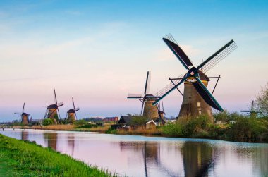 Günbatımında Hollanda, Kinderdijk 'te rüzgar değirmenleriyle nefes kesici bir manzara. Büyüleyici yerler, turistik yerler..