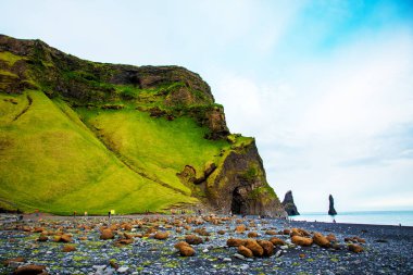 Reynisdrangar Deniz Kayalıkları üzerinde siyah kum plajda bazalt kaya mağara ile güzel dramatik manzara, Vik yakınlarındaki Reynisfjall Dağı altında Troll denilen taşlar, İzlanda. Egzotik ülkeler.