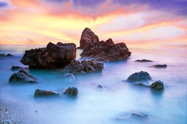 Pitoresk büyülü mistik güzel bir sahne dalgalar ve gün batımında sahilde denizin ortasında taşlar ile. (meditasyon, antistress, gevşeme - kavram)