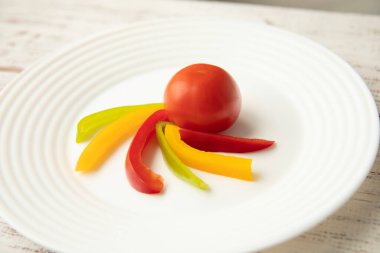 Beyaz tabakta domates ve Bulgar kırmızı sarı biber dilimleri