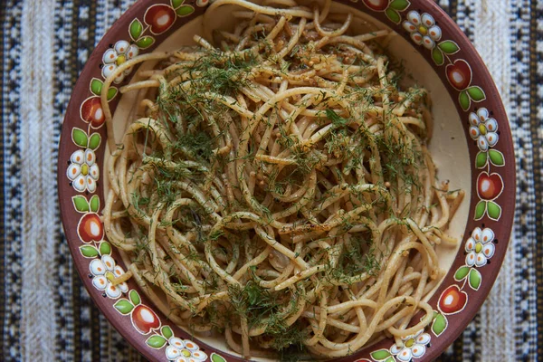 spagetti geleneksel yemek çanak çömlek masa örtüsünü yeşillendirir.