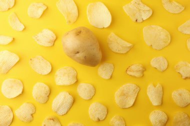Sarı arka planda bir patates cipsi ve çıtır patates cipsi. Resim üst görünümü, düz yatış.