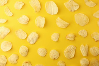 Sarı arka planda çıtır patates cipsi. Resim üst görünümü, düz la