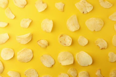 Sarı arka planda çıtır patates cipsi. Resim üst görünümü, düz yatış