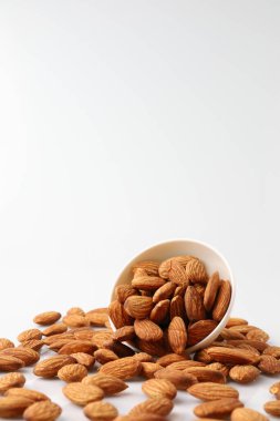 Beyaz fındıklı badem fıstıkları beyaz arka planda izole edildiğinde serbest radikallerin etkisiz hale getirilmesinde, Alzheimer hastalığının önlenmesinde, vücuttaki aşınma ve yırtığın onarılmasında yardımcı olur..