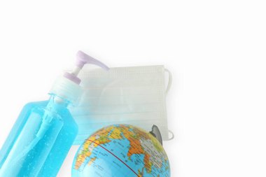 Virüsün beyaz arka plan fotokopi alanına yayılmasını engellemek için alkol jeli ve tıbbi maskeli dünya simülasyonu. Virüse karşı kavram savaşı