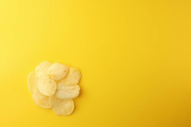 Sarı arka planda çıtır patates cipsi. Resim üst görünümü, düz görünüm ve boşluk kopyala.
