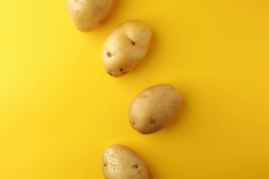 Sarı arka planda patates. Resim üst görünümü, düz görünüm ve boşluk kopyala.