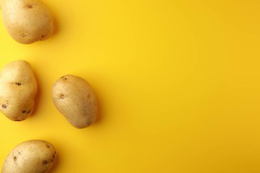Sarı arka planda patates. Resim üst görünümü, düz görünüm ve boşluk kopyala.