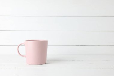 Beyaz ahşap arka planda, fotokopi saplı pembe kahve kupası..
