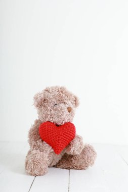 Beyaz tahtada kırmızı kalpli oyuncak ayı. Aşk kavramı, kopyalama alanı ile sevgililer günü.