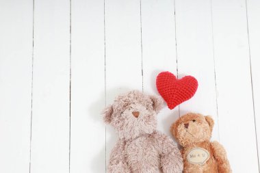 Beyaz ahşap düz manzaralı kırmızı kalpli oyuncak ayı çifti. Aşk kavramı, kopyalama alanı ile sevgililer günü.