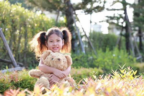 Asia Kind Mädchen Stehen Umarmt Einen Teddybär Park Mit Sonnenuntergang — Stockfoto
