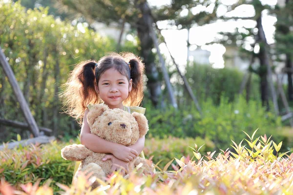 Asia Capretto Ragazza Stand Abbracciato Orsacchiotto Nel Parco Con Sole — Foto Stock