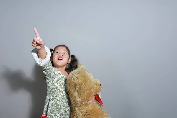 Πορτρέτο Ασιατικό Κορίτσι Στέκεται Αγκαλιά Αρκουδάκι Δεξί Χέρι Έδειξε Την — Φωτογραφία Αρχείου