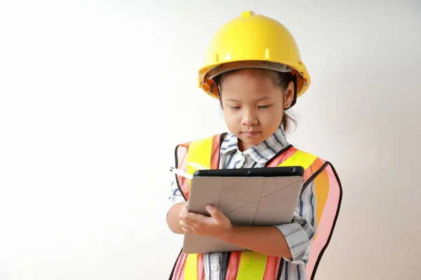 Yansıtıcı gömlek giyen Asyalı bir çocuk portresi ve tablete kasket güvenlik kaydı. Öğrenmeye ve geliştirmeye, küçük mimar..