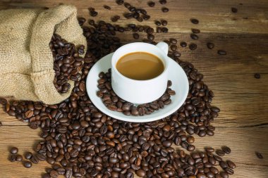 Kahve fincanı ve kahve çekirdekleri masa tahtasında. metin için boşluk kopyala.