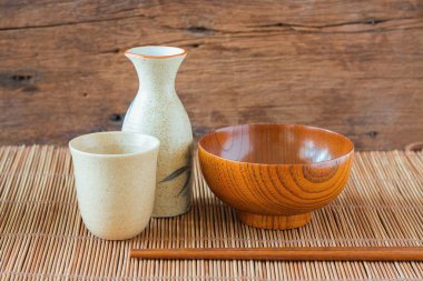 Yemek çubukları ve masaya saki şişesi koyulmuş bir odun. Metin için kopyalama alanı ile.