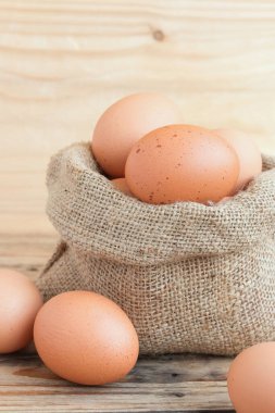 Tahta masadaki çanta içinde taze tavuk yumurtası. Metin yazmak için boşluk kopyala.