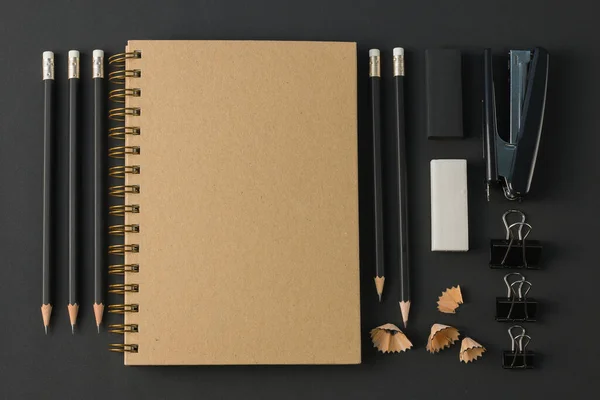Ofis kağıtları, ataç kağıdı, silgi, siyah masa üzerindeki kalem düzlüğü. Üst görünümde kopyalama alanı var.
