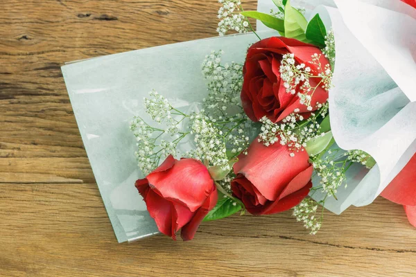 Valentines day, symbol love, red roses bouquet on wooden table. with copy space for text.