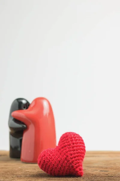 Red heart yarn with doll couple in hug on old wooden table. love concept. copy space for massage.