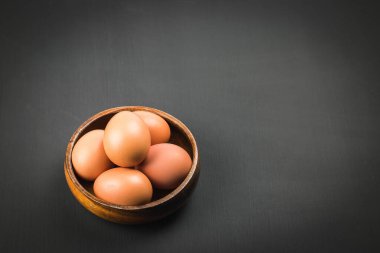 Tahtadaki yumurtalar siyah kontrplak arka planda. Menü metnini yazmak için sağ tarafta kopyalama alanı ile.