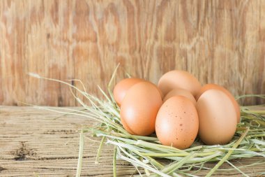 Ahşap arka planda saman içinde yumurtalar. Metin yazmak için sol tarafında kopyalama alanı ile.