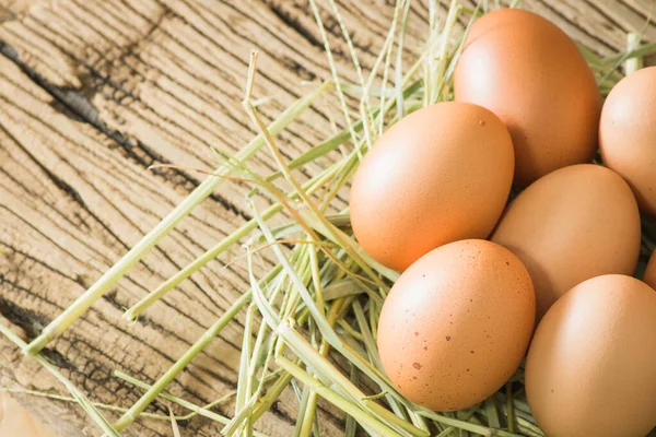 Ahşap arka planda saman içinde yumurtalar. Metin yazmak için sol tarafında kopyalama alanı ile.
