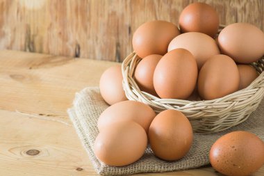 Tahta arka planda sepette yumurtalar. Metin yazmak için sol tarafında kopyalama alanı ile.