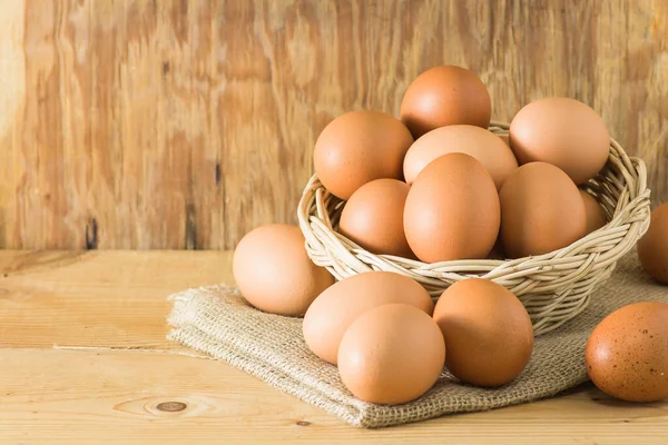 Tahta arka planda sepette yumurtalar. Metin yazmak için sol tarafında kopyalama alanı ile.