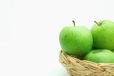 Hasır sepetteki taze yeşil elmalar. Beyaz arka planda izole edilmiş. metin için kopyalama alanı ile.