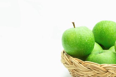 Hasır sepetteki taze yeşil elmalar. Beyaz arka planda izole edilmiş. metin için kopyalama alanı ile.