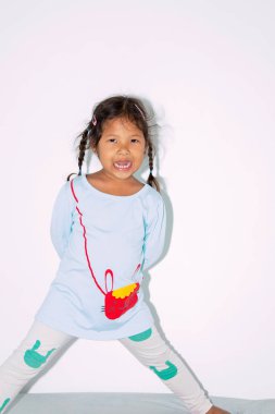 Güzel Asyalı çocuk yatağında mutlu bir şekilde gülümsüyor..