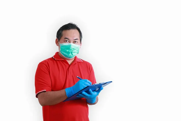 Portrait Asian employees wear red uniforms, wear a blue glove, and the medical mask for protection coronavirus. Writing a message in blue clipboard isolated on white background with copy space.