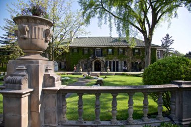 Toronto, Ontario / Kanada - 20 Mayıs 2016: Önü çitlerle çevrili manzara bahçeli Gotik tarzı bina.