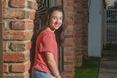 Beyaz kız kameraya bakıyor tuğla arka planda