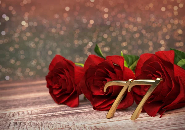 Concetto di compleanno con rose rosse sulla scrivania in legno. Settantasette. 77esima. Rendering 3D — Foto Stock