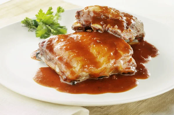 baked ribs with sauce on white plate