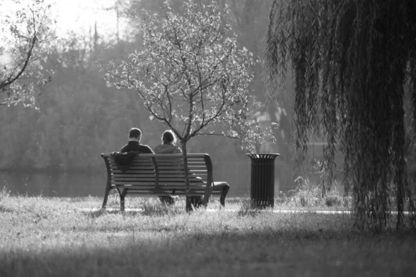 A man and a woman on a bench in a city Park on a warm autumn day