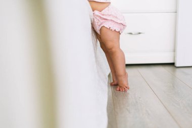 Evdeki yatağın yanında küçük şirin bacaklar.