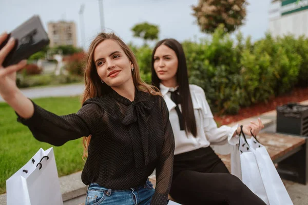 Dos Hermosas Mujeres Caucásicas Jóvenes Sientan Banco Con Bolsas Frente — Foto de Stock